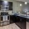 A kitchen with black cabinets at Landmark Conservancy apartments in Bee Cave, TX.